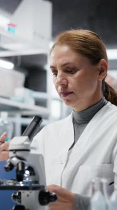 Woman Scientist Analyzing Test Tube Sample Using Microscope