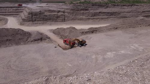 Excavator Loading Truck at Daytime Quarry from Above