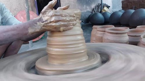 Pot en argile façonné à la main sur une roue de potier. Mains d'un potier indien au travail moulant un vase en argile. Casserole