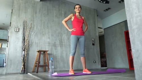 Portrait of Sporty Woman Resting on Mat by Window in Gym 30s