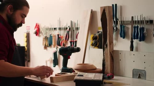 Carpenter Changing Power Drill Head in Furniture Assembly Shop