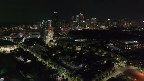 Aerial panoramic view of night city. Illuminated streets and buildings. Cityscape with downtown skys