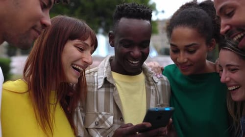 Friends Laughing Together While Looking at Smartphone