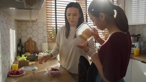 Caucasian mother giving a lunch box to daughter to school. Shot with RED helium camera in 8K.