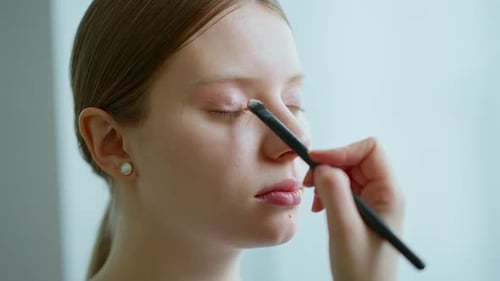 Visagistin arbeitet in ihrem Schönheitsstudio, Porträt einer Frau bei der Bewerbung durch einen professionellen Make-up-Meister