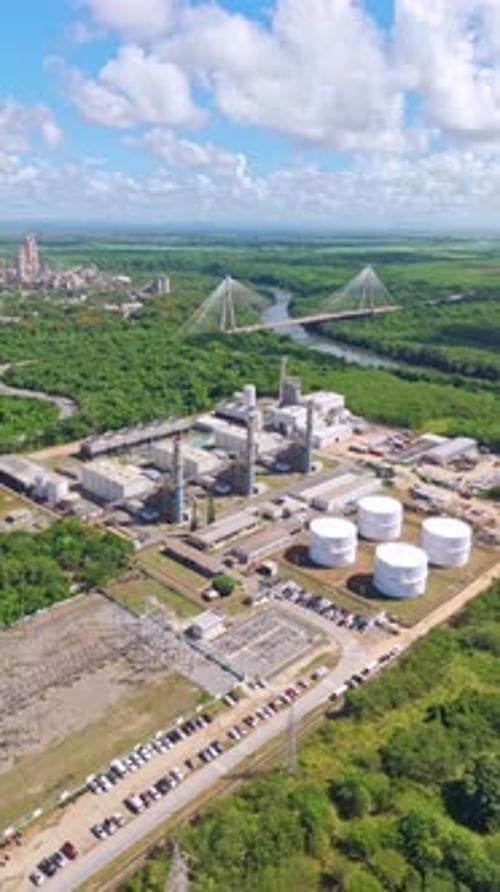 Pan view of the Energa 4 power generation facility, fuel storage tanks, substation, and smokestacks