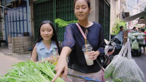 Asian Mother and Daughter Buying Traditional Asian Street Food Vegetables From Street