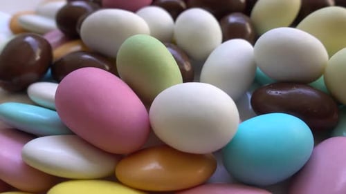 Pile of almonds or colored pine nut almonds. Easter season.