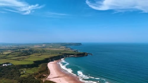 Stunning panorama of a rocky shore of Ireland with blue waterscape and sky.