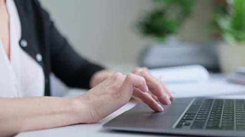 Adult Hands Using Trackpad on Laptop at Desk