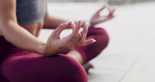 4k video footage of an unrecognizable sportswoman meditating and practicing yoga on the beach