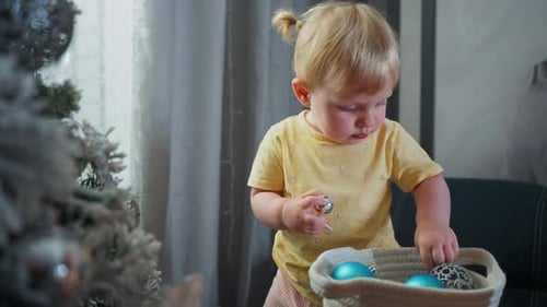 Child Decorates Christmas Tree at Home