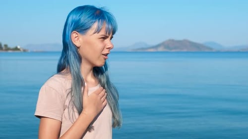 Young Adult Using Inhaler By the Ocean