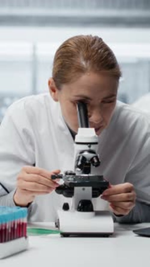 Woman Works With Microscope in Laboratory Setting