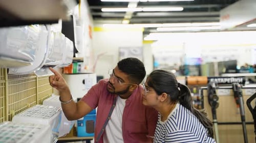 Indian Couple Choosing Air Conditioner in Home Appliance Store for New Home