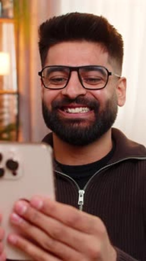 Enthusiastic Man Video Calling on Smartphone Indoors