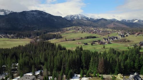 Drohnenblick auf das kleine Dorf in den Bergen bei sonnigem Tag