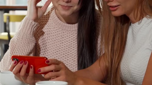 Two Young Women Enjoying Coffee and Smartphones