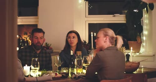 Friends Gather Around Table With Wine and Food