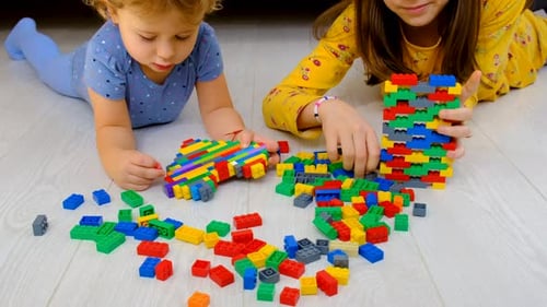 Children Play with Colorful Toy Blocks at Home