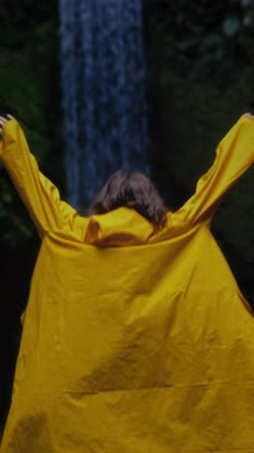 Woman Enjoying a Waterfall at Night