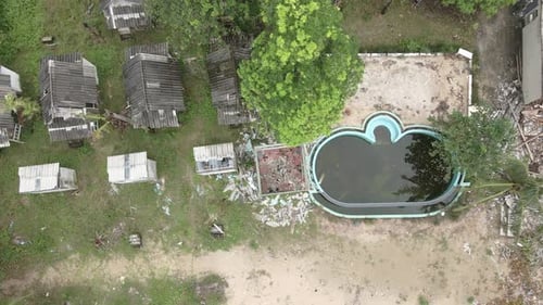 Aerial birds eye view left moving trucking shot of a abandoned derelict destroyed beach resort with