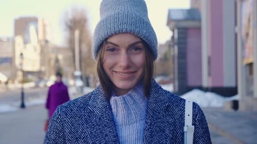 Woman Smiling in Grey Hat on City Street