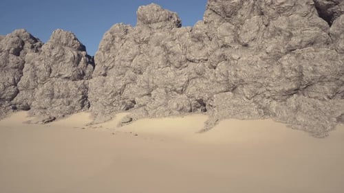 Majestic Rocky Outcrops Alongside Expansive Sweeping Dunes Under Clear Skies