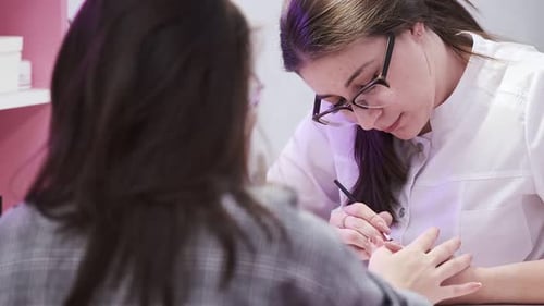 Nail Technician Applying Polish in Salon
