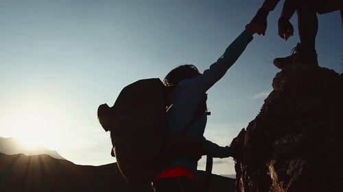 Man Gives A Hand Helps Woman To Climb Up Mountain