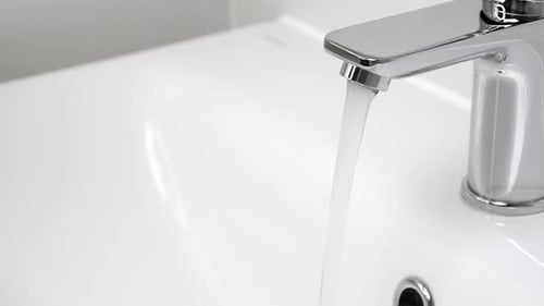 Running Faucet Water in a Modern White Sink