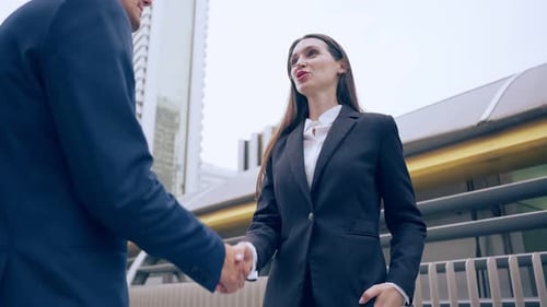 Caucasian businessman and businesswoman handshake outdoor in the city.