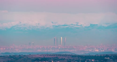 Madrid city skyline and snowy mountains Sierra de Guadarrama during sunrise winter night to day time