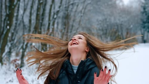 Woman Tossing Hair in Snowy Winter Forest