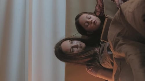 Mother and Child Reading Book Together at Night