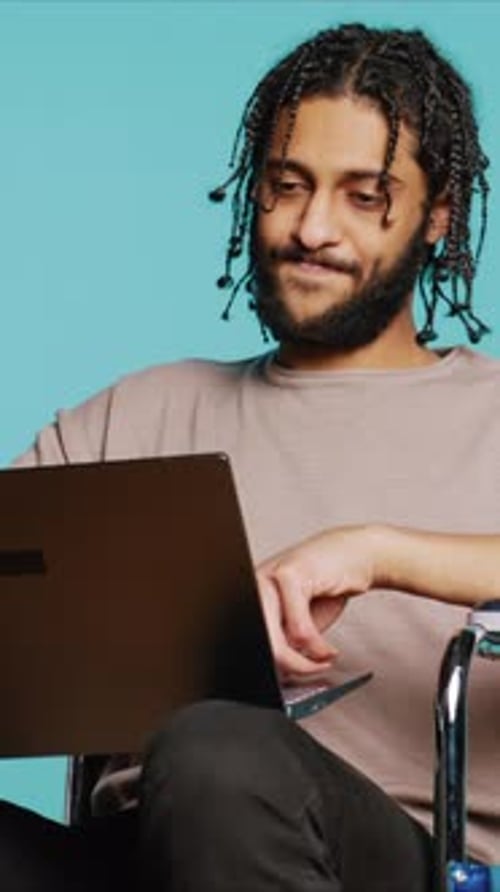 Vertical Video Man in Wheelchair Chatting with Friend Over Internet Videocall Using Laptop