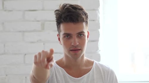 Young Adult Man Points Directly at Camera