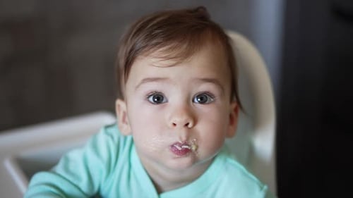 Cute Baby Sitting in High Chair Reaching Out