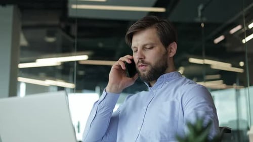 Busy Young Professional Juggling Work on a Phone Call