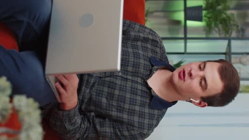 Young Adult Video Calling on Laptop at Home