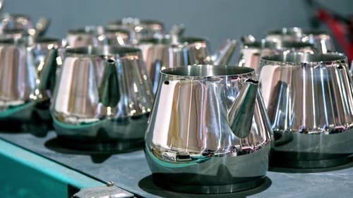 Finished Metal Teapots on Production Line Polished Kitchenware Manufacturing