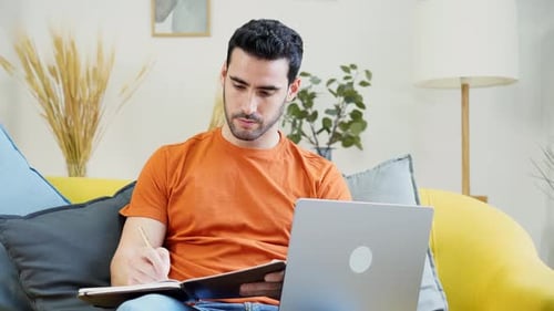 Young Adult Works on Laptop at Home