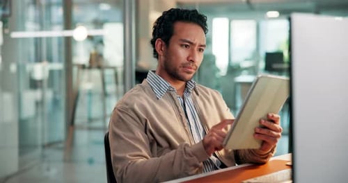 Man uses tablet at desk in modern office