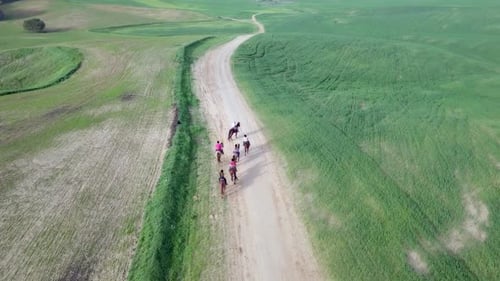Horseback riding in a green Badlands terrain, aerial footage