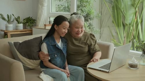 Grandmother and Grandchild Using Laptop Together Indoors