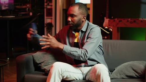 Man Plays Video Games Wearing Headphones on Couch