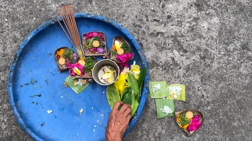 Mujer balinesa haciendo una ofrenda de canang sari para un ritual hindú matutino en Bali