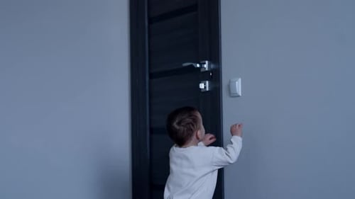 Cute Baby Reaches for a Light Switch at Home