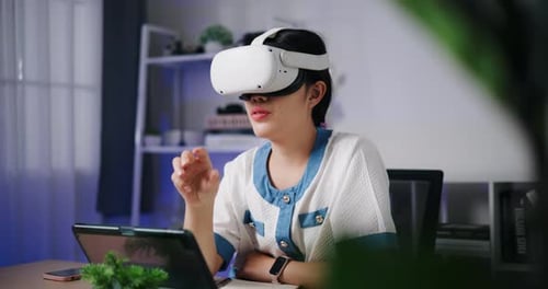Woman Uses Virtual Reality Headset at Desk