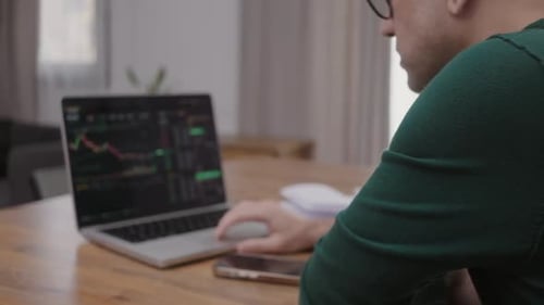 Back View of Man Analysing Stock Market Charts on Laptop Bitcoin and Crypto Currency Investment